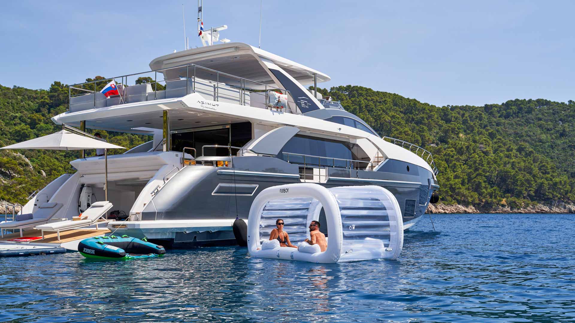 Side vew of people enjoying inflatable water toys