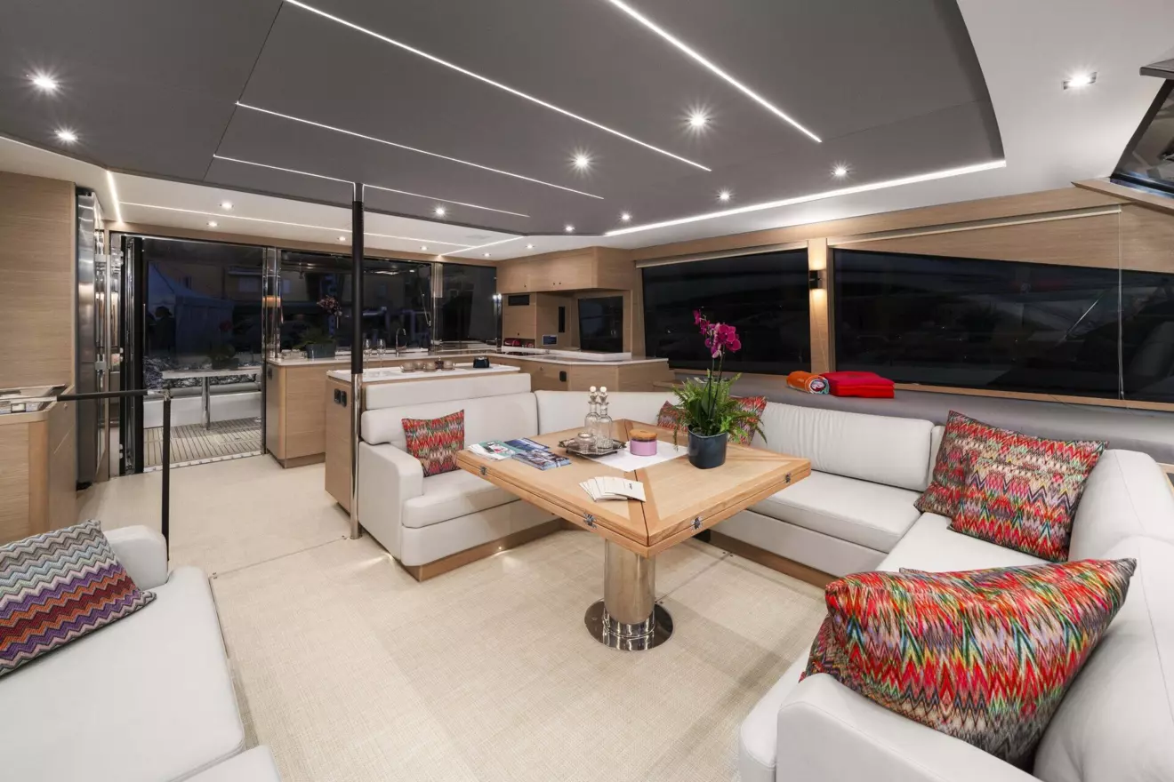 Spacious salon of the Aquila 54 catamaran, featuring a comfortable seating area and a well-equipped kitchen.