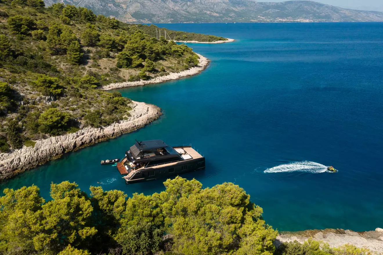 A catamaran anchored in a secluded bay off the coast of Croatia.