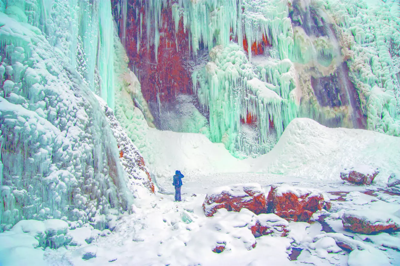 A close-up of a frozen waterfall with icicles glistening in the winter sunlight at Plitvice Lakes.