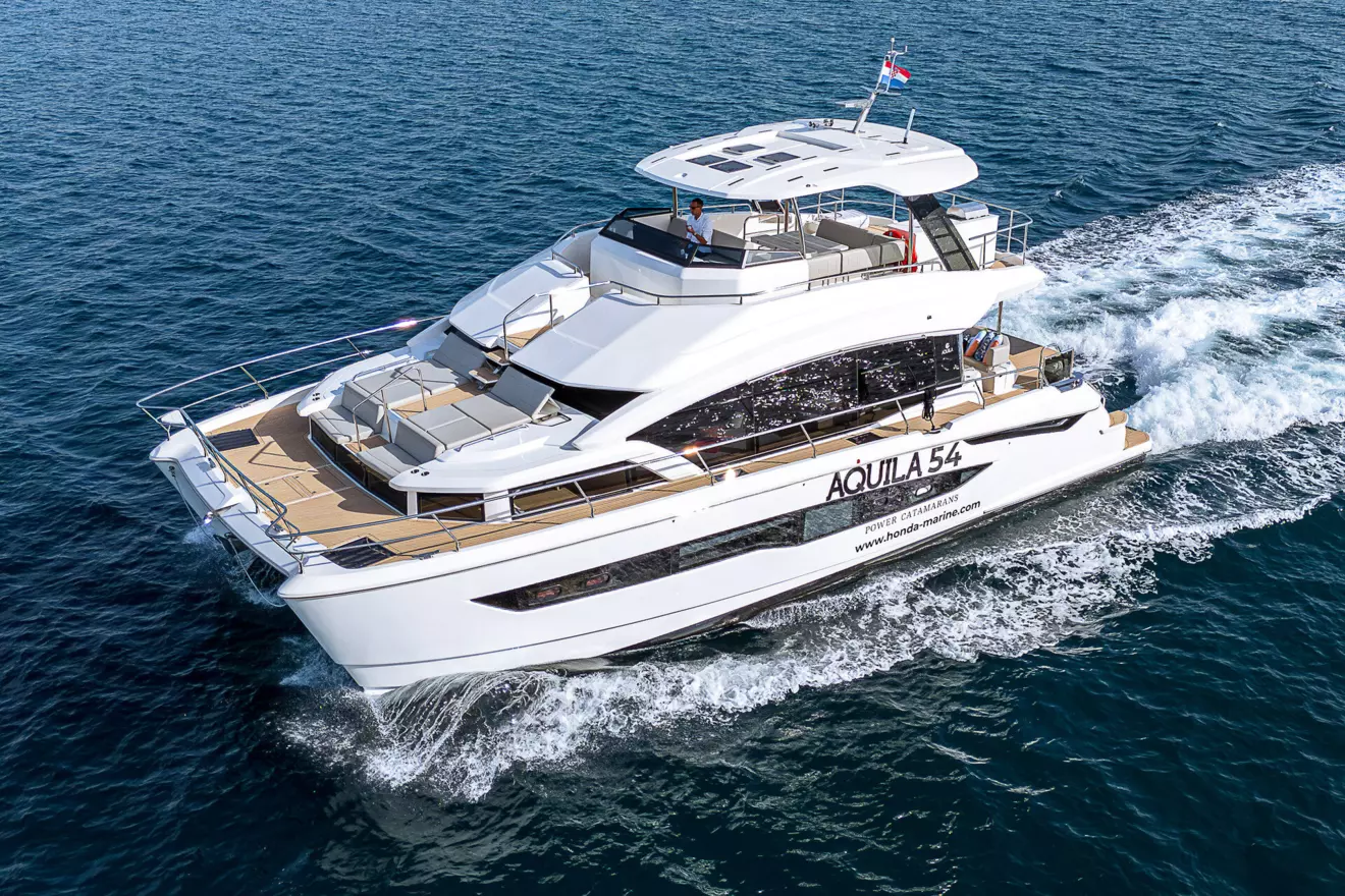 Side view of the Aquila 54 catamaran, highlighting its distinctive hull design and large windows.
