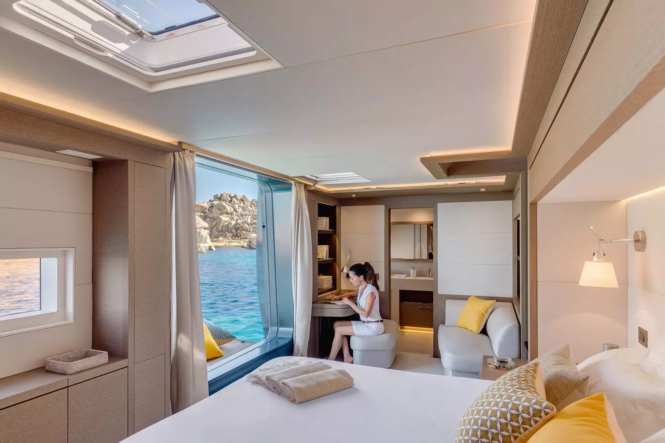 A woman enjoys the luxurious amenities of a cabin on a Lagoon Seventy 7 catamaran .