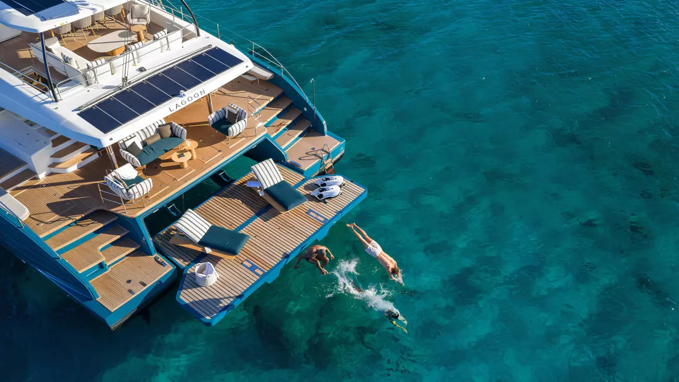 The Lagoon 82 luxury catamaran stern deck with lowered hydraulic swim platform and solar panels, perfect for enjoying the turquoise sea