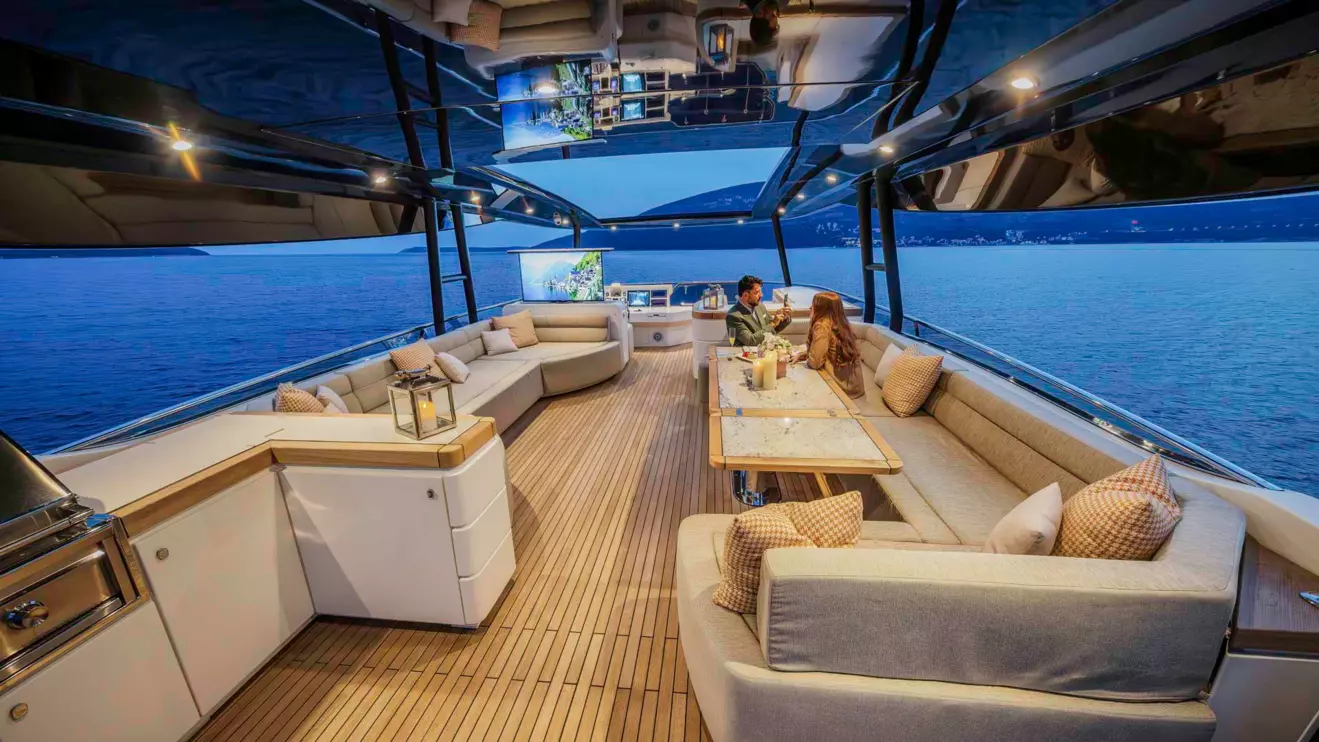 A luxury yacht flybridge at night with a view of the sea, highlighting the comfortable onboard living.