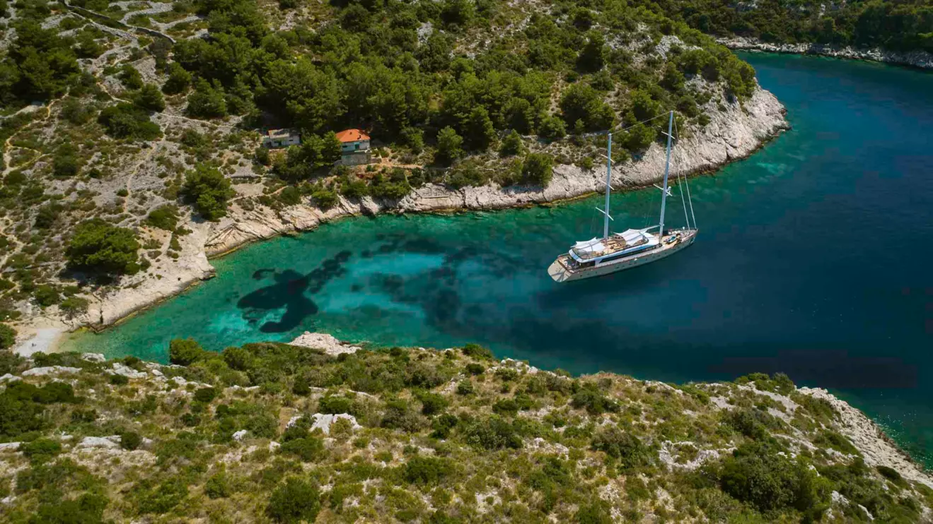 Secluded cove in Croatia with crystal-clear water, representing a private anchorage for yacht charters.