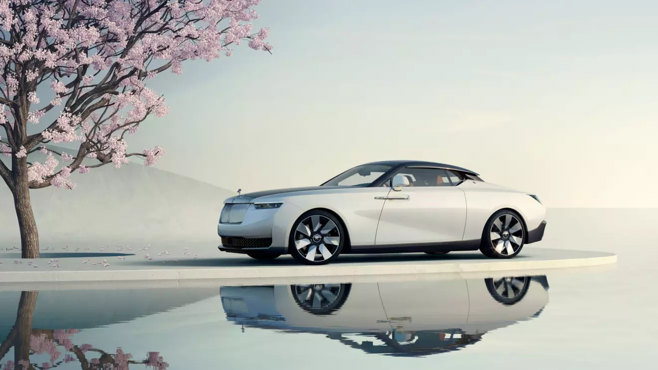 The Rolls-Royce Arcadia Droptail, a coachbuilt luxury convertible, showcased in a serene outdoor setting with a cherry blossom tree, highlighting its elegant design.