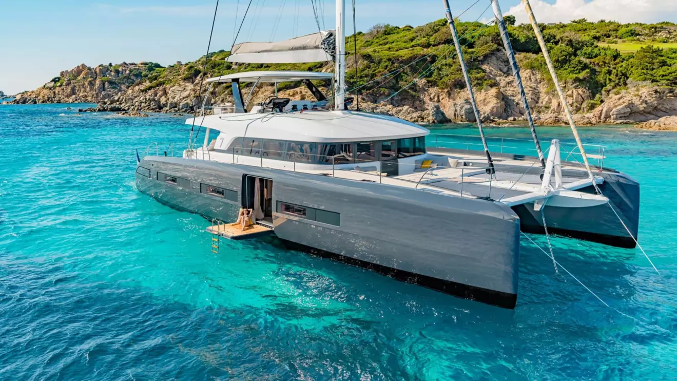 Lagoon Seventy 7 luxury sailing catamaran is anchored in a turquoise bay. 