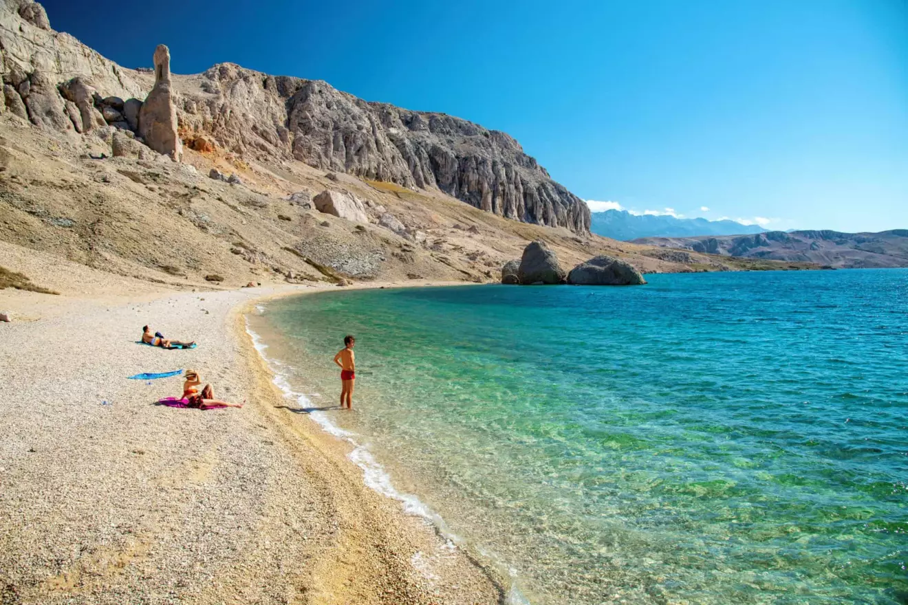 People enjoying the secluded beauty of Beritnica beach on Pag Island.