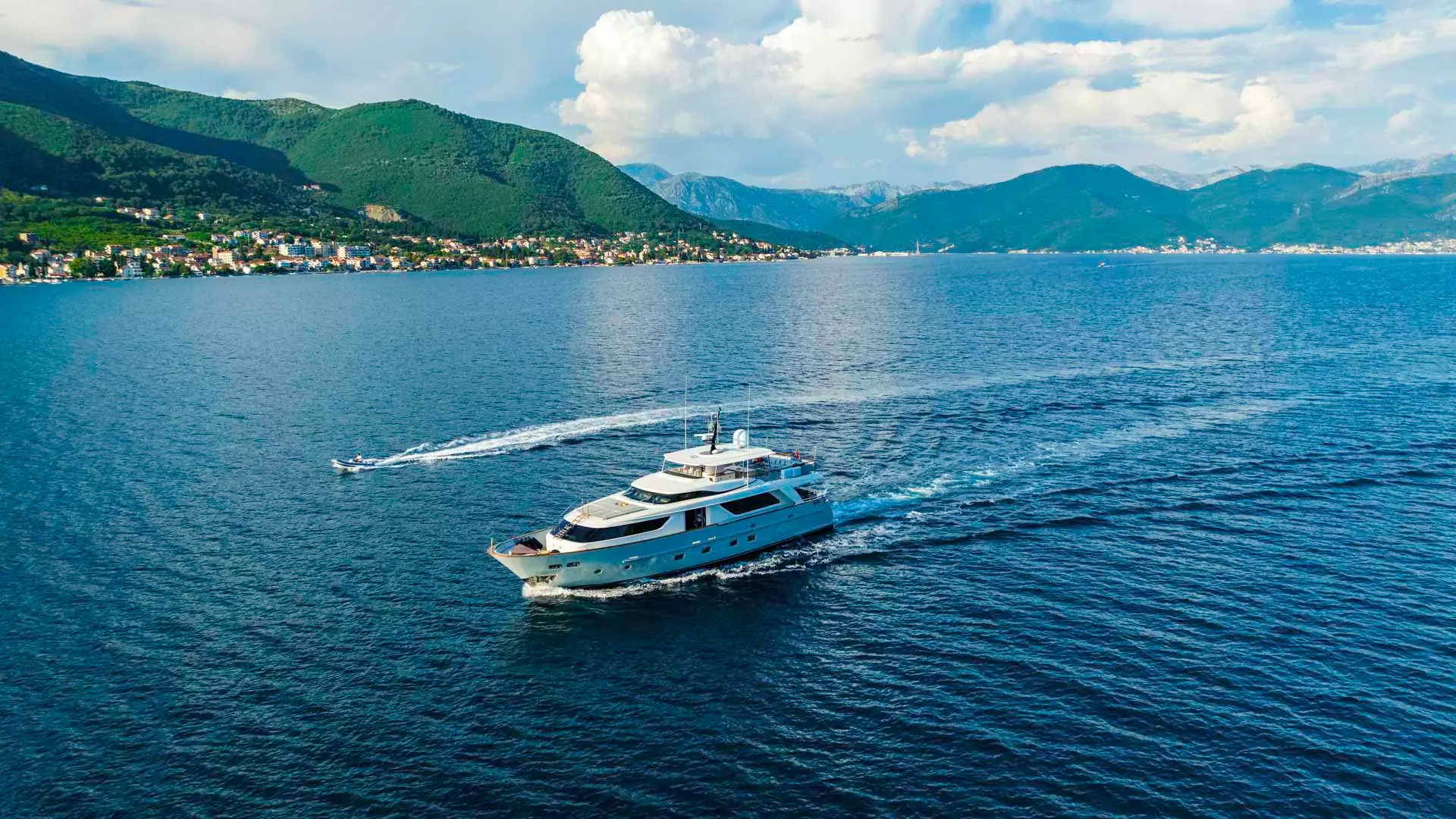 Yacht and tender cruising across sea