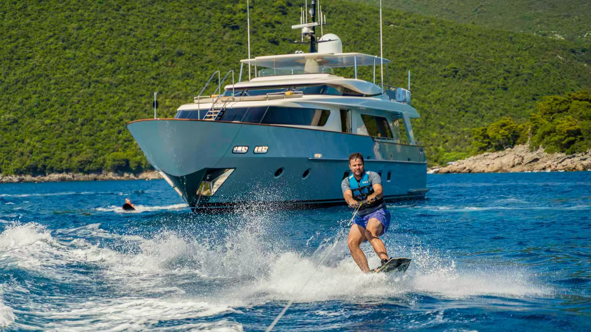 Guest water skiing aboard a luxury yacht