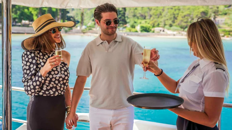 Crew serving guests aboard luxury yacht