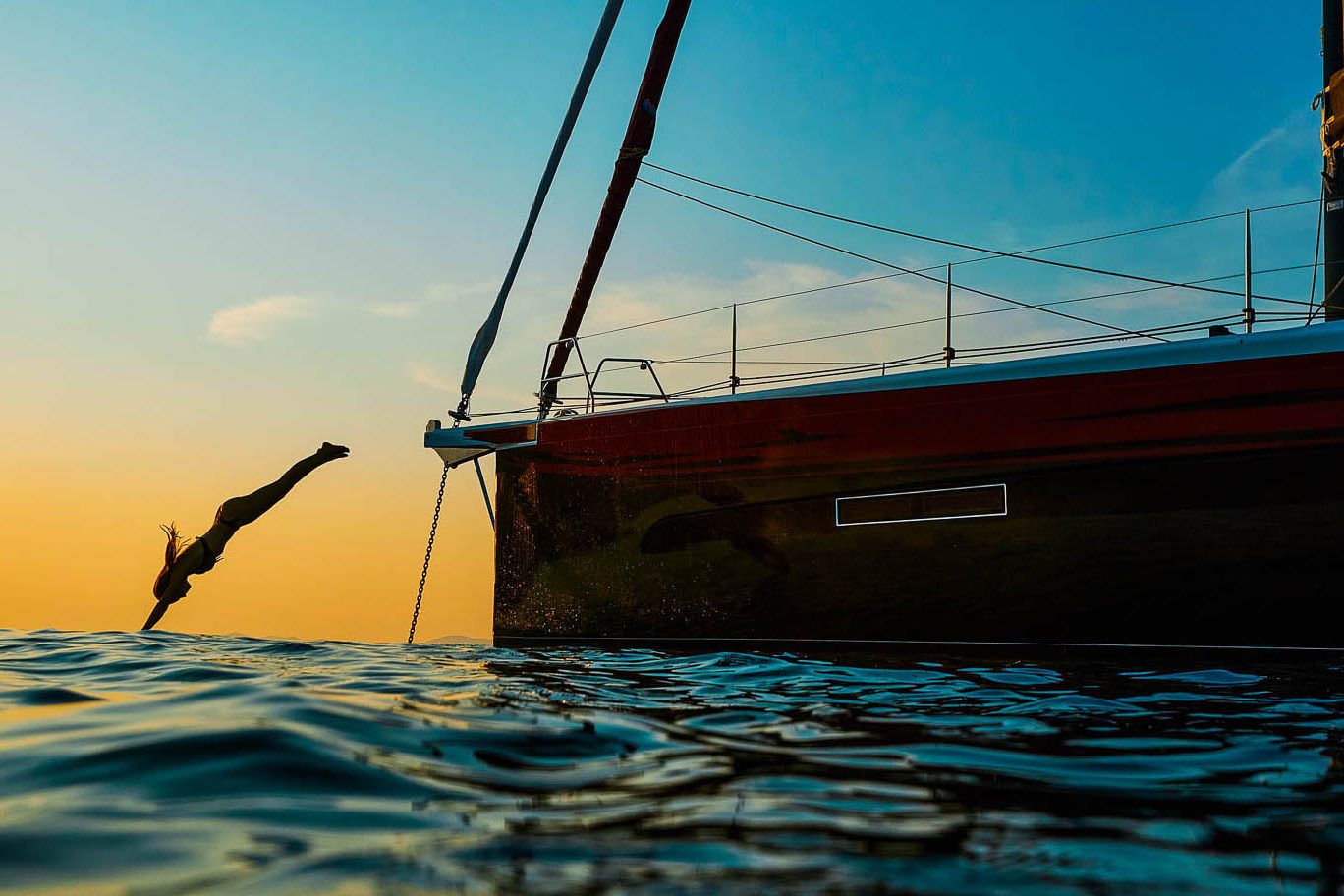 This is photo of a sailing boat Dufour 56 at sunset on sea