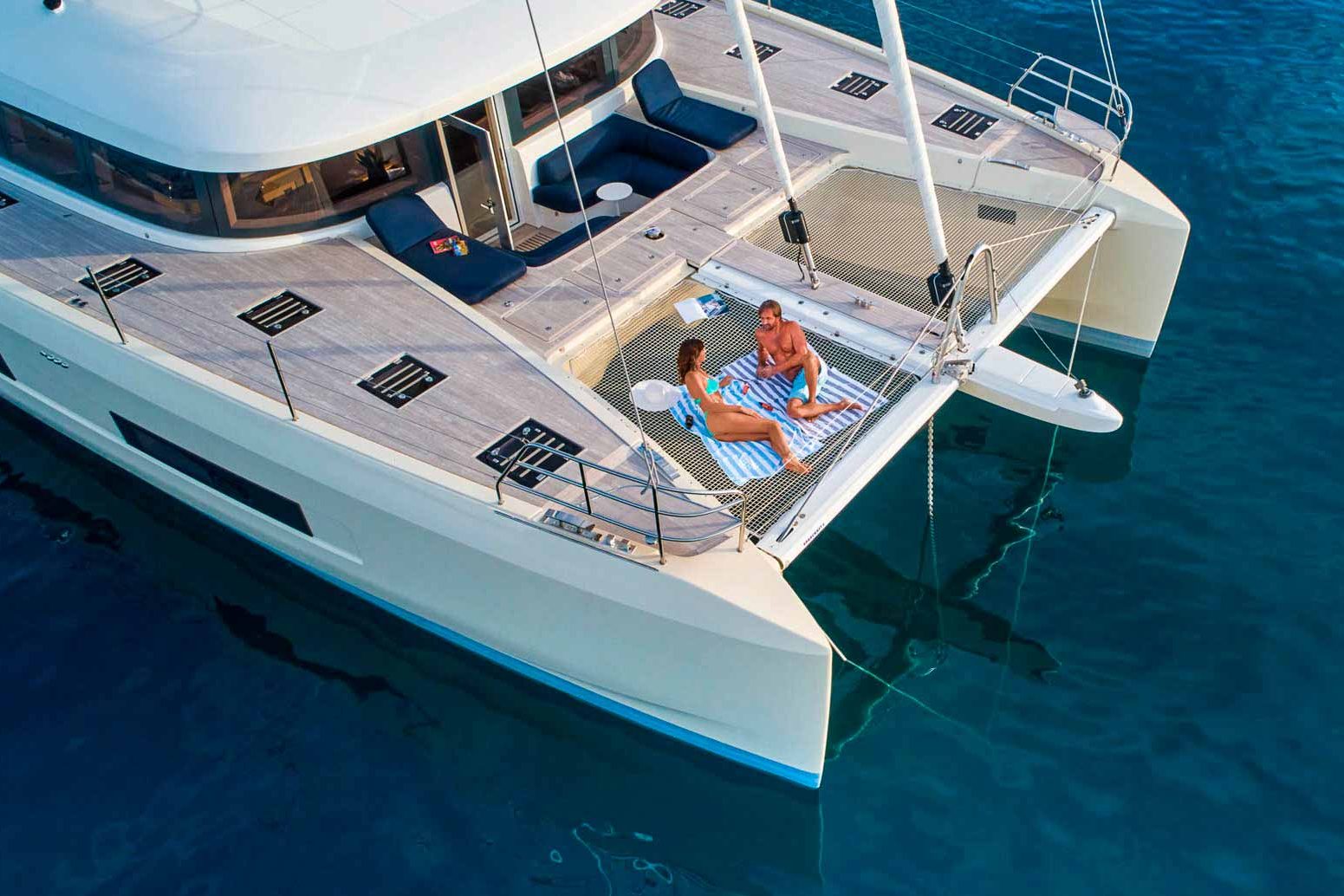 This is photo of a catamaran Lagoon Sixty5 named Amada Mia sunbathing net, aerial view